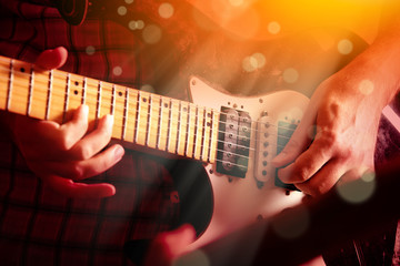 Life style image of close up young male guitarist hand, playing electric guitar