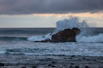 Naklejka na ściany i meble Wave Crashing against a Rock in the Pacific Ocean