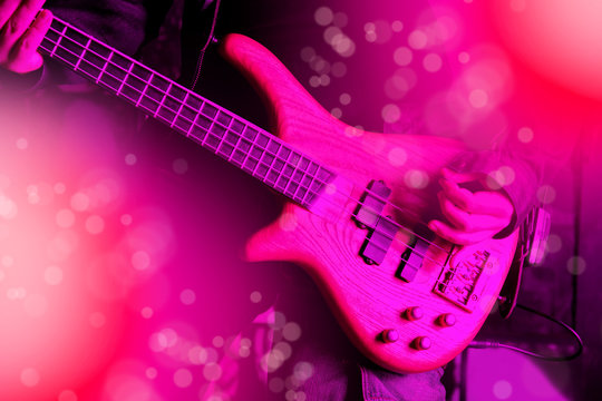 Life style image of close up young man hand, playing electric bass guitar