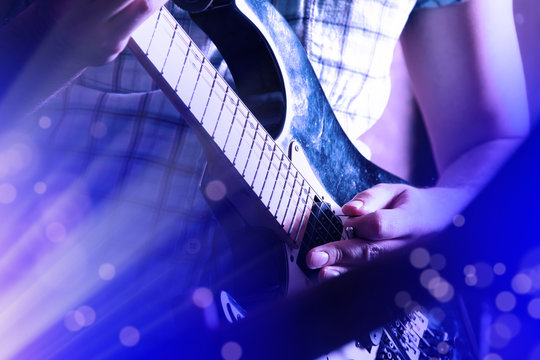 Life style image of close up young male guitarist hand, playing electric guitar