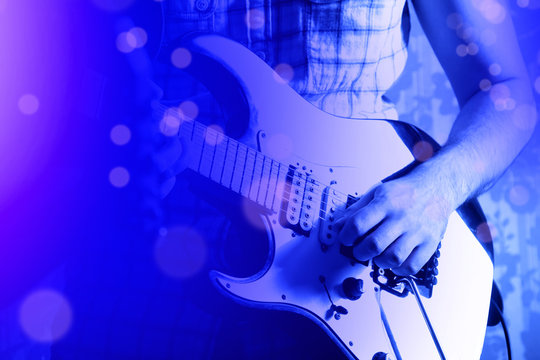 Life style image of close up young male guitarist hand, playing electric guitar