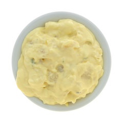 Top view of a portion of potato and egg salad in a small bowl isolated on a white background.