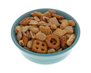 A small bowl filled with peanuts and an assortment of crunchy pretzels and waffle crackers isolated on a white background.