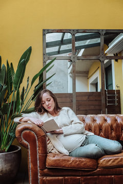 Portrait of a pregnant woman reading