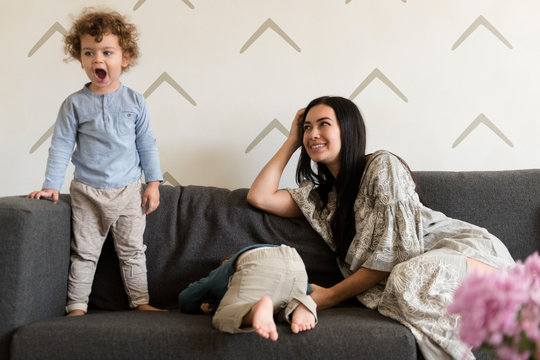 Mother smiling at her two boys having tantrums