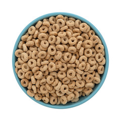 Top view of a blue bowl filled with toasted oat cereal isolated on a white background.