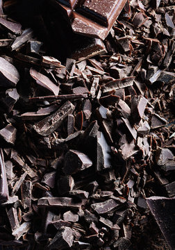 Chocolate. Shards of chopped chocolate on metal background.