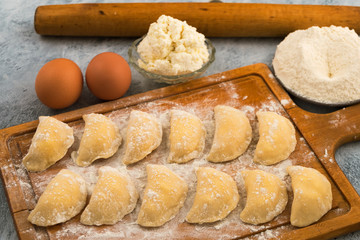 Semi-finished dough with cottage cheese, laid out on a cutting kitchen Board.