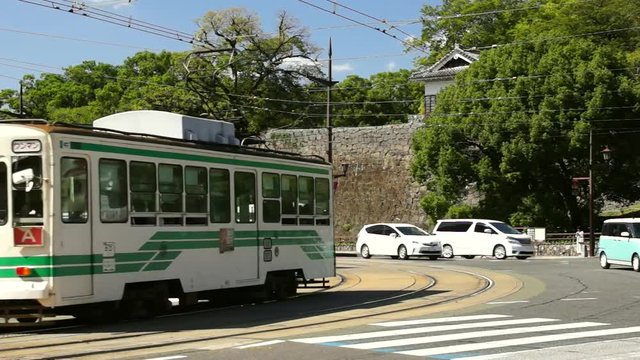 熊本城石垣をバックに走る路面電車