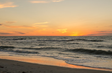 Fototapeta na wymiar Sunset or sunrise over the ocean with orange and yellow tones
