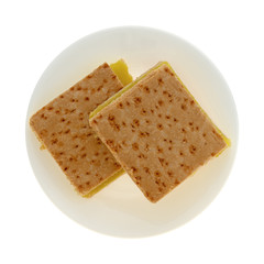 Top view of two freshly baked lemon squares on a plate isolated on a white background.