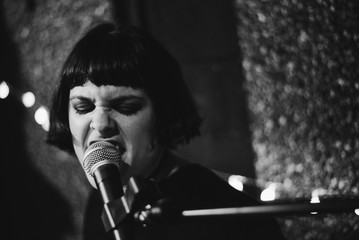 Drummer girl playing and singing during a rehearsal