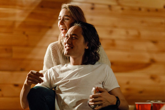 Laughing couple embrace while watching friends play pool