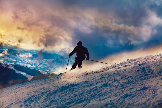 Skier Going Downhill At Sunset