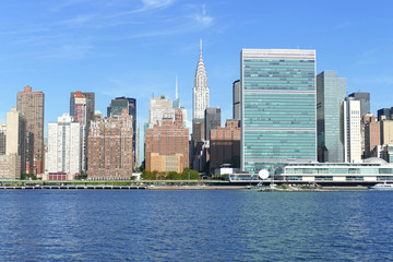 New York City Skyline, East River and Manhattan, New York waterfront on a sunny day with blue sky in background