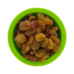Top view of a small green bowl filled with golden raisins isolated on a white background.