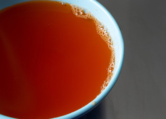 Close view of a bowl of orange flavor gelatin on a stainless steel counter top.
