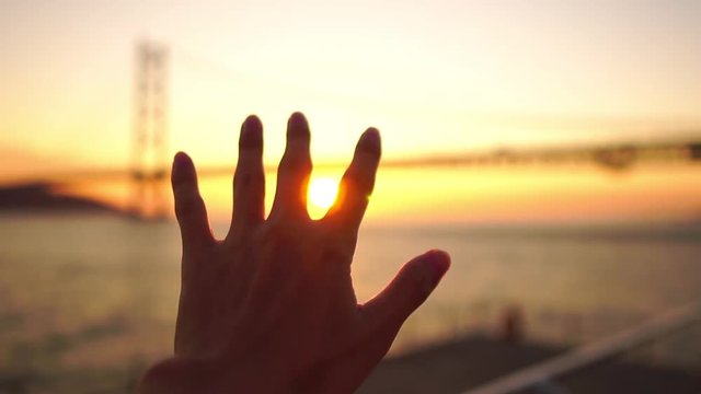 夕陽に手をかざす男性