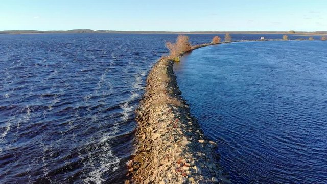 Breakwater in high wind separates troubled waters from calm. 
