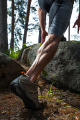 Muscled leg of a trail running athlete running in the forest