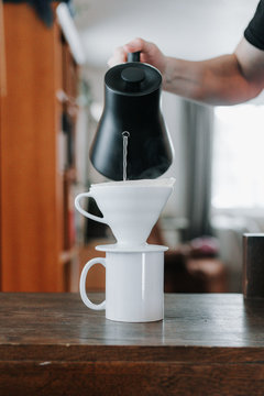 Carefully pouring water into a brewing cone
