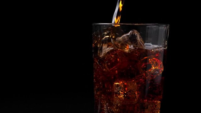 Pouring coca cola into the glass