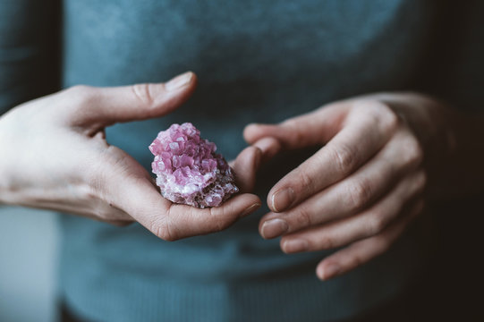Woman holding pink crystal in her hands