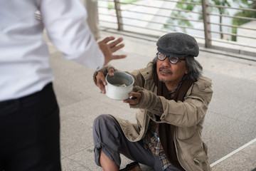 Old homeless man ask for money in city