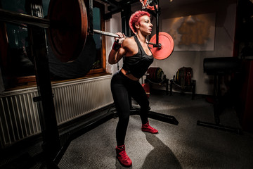 Fototapeta na wymiar Woman doing squats in the gym