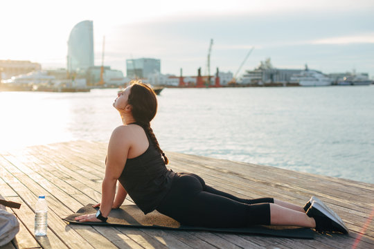 Plus Size Woman Exercising At Seaside On Morning.