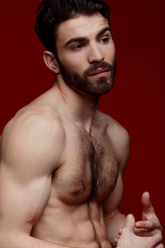 Handsome shirtless strong man portrait over red background