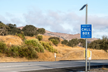 A highway call box along a rural roadside serves to help drivers in an emergency situation