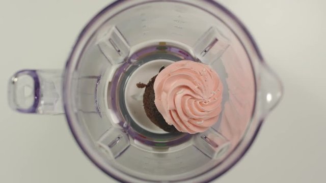 SLOW MOTION: Cupcake falls into mixer from a hand