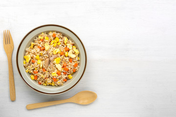 fried rice with tuna and vegetable in a ceramic dish, copy space for text. homemade style food concept.