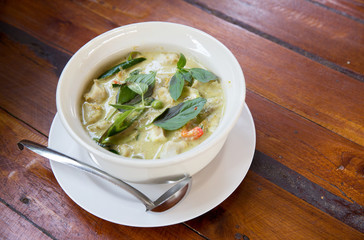 Thai chicken green curry with old wooden background.closeup green curry with chicken (Kang Keaw Wan Gai) isolated on white background, Thai local food.