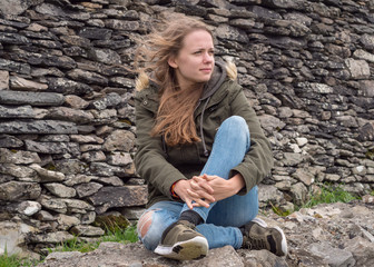 Fototapeta premium Young 20 year old girl relaxes at the west coast of Ireland
