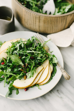 Angled view of pear and arugula salad with champagne vinaigrette