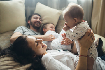 Smiling family relaxing on bed at home
