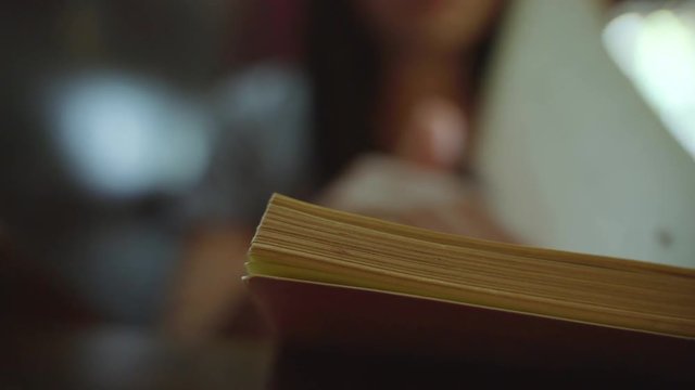 woman hand flipping book pages while reading
