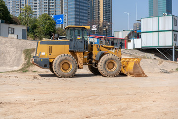 industrial building construction site mini bulldozer levelling and moving soil during highway building