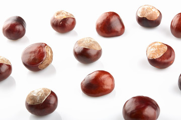 Many peeled chestnuts lie on white background