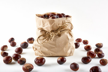 Chestnuts in paper bag on white background