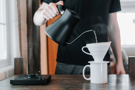 Carefully pouring water into a brewing cone
