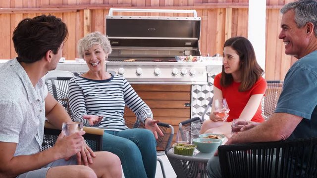 Senior couple and adult children talking in their backyard