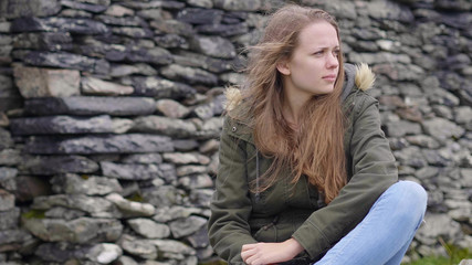 Young woman sits on the ground - seems to be sad