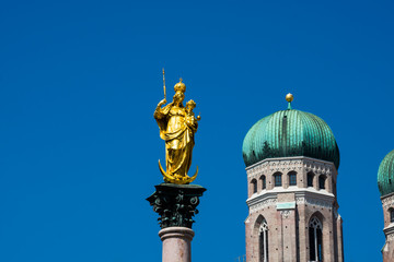 Fototapeta na wymiar Mary's Column (Mariensaule) at Mary's Square (Marienplatz) Frauenkirche (Munich cathedral) in the background. Munich, Germany