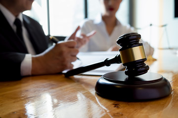 Judge gavel with Justice lawyers having team meeting at law firm background. Concepts of Law and Legal services.