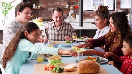Multi Generation Family Enjoying Meal Around Table At Home - Powered by Adobe