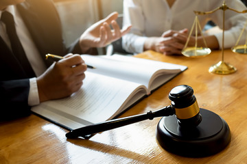 Judge gavel with Justice lawyers having team meeting at law firm background. Concepts of Law and...