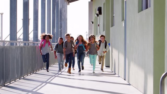 Elementary school kids running to camera in school corridor